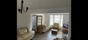 a living room with a couch and chairs and a tv at Enfield Street house behind Portstewart promenade with partial sea view from front 3 bed sleeps 7 in Portstewart