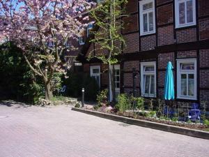 een gebouw met een blauwe paraplu en stoelen en een boom bij Ferienwohnungen Ehlers-Bastelstudio in Bad Bevensen