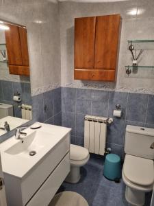 een badkamer met een witte wastafel en een toilet bij Bajo con Jardin en Cartes in Cartes