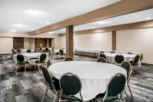 uma sala de conferências com mesas e cadeiras brancas em Oasis Inn Tacoma em Tacoma