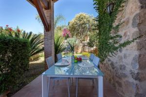 una mesa azul con sillas en el patio en VILLA TAMARIT, en Pedralba