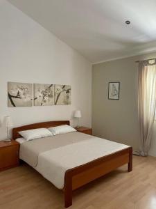 a bedroom with a bed and two lamps and a window at Apartment Araucaria Gallery in Crikvenica