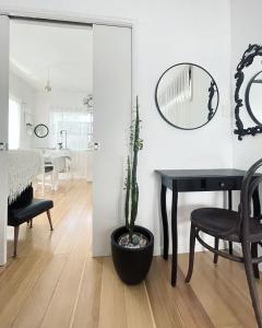 a dining room with a table and a potted plant at The White Cottage Byron Bay in Suffolk Park