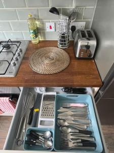 a drawer in a kitchen filled with utensils at Harrow Town Centre 3 Bed Flat - Sleep up to 5 people, close to London Underground in Harrow