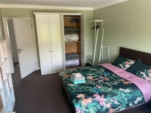 a bedroom with a bed with a floral bedspread at Harrow Town Centre 3 Bed Flat - Sleep up to 5 people, close to London Underground in Harrow