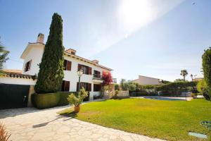 ein großes weißes Haus mit einem Rasenhof in der Unterkunft Great home with AC, pool and BBQ in El Campello