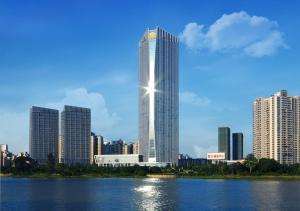 ein hohes Gebäude vor einer Skyline der Stadt in der Unterkunft Renaissance Huizhou Hotel in Huizhou
