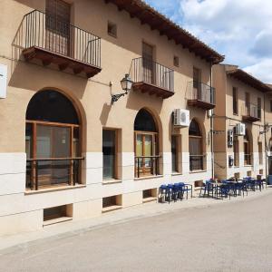 un edificio con sillas y mesas a un lado. en Hostal Tastavins, en Peñarroya de Tastavins