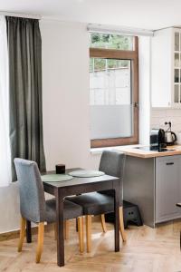 a kitchen with a table and two chairs and a counter at Monbuhim Comfort in Veszprém