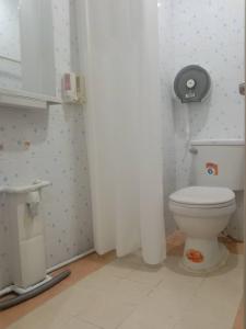 a bathroom with a white toilet in a room at Longzhu Guesthouse in Bangkok