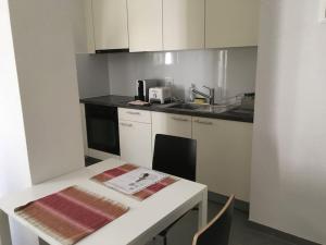 洛桑的住宿－Appartement meublé proche de la Gare de Lausanne 12，厨房配有白色橱柜和白色台面
