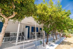 una fila di alberi di fronte a un edificio di Zante Riva Studios a Lithakia