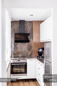 a kitchen with white cabinets and a stainless steel oven at City Center Turu str apartments, parking, Tartu Home in Tartu