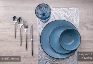 a table with a blue plate and cutlery at City Center Turu str apartments, parking, Tartu Home in Tartu