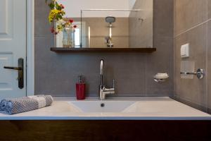 a white sink in a bathroom with a mirror at Andrikos Studios in (( Kalodhikátika ))