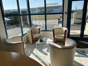 a restaurant with chairs and a table and a window at Hôtel Le Laury's in Onet le Château