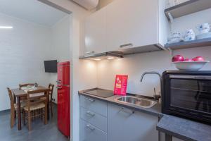 a small kitchen with a red refrigerator and a sink at La Casa di Vitto by Wonderful Italy in Turin