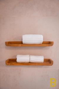two wooden shelves with towels on a wall at BePlace Apartments in Chinatown in Milan