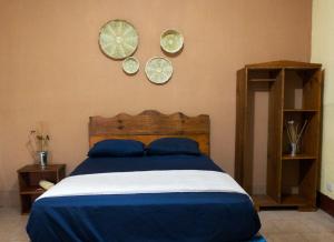 Guastatoya的住宿－Hotel Israel，卧室配有一张床,墙上挂着三个盘子