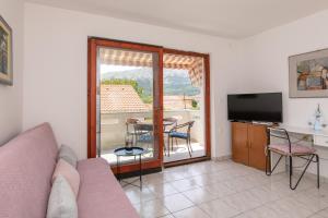 un soggiorno con un divano e un tavolo con sedie di Apartment Valkovic a Baška