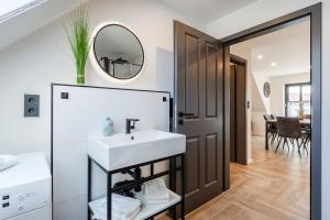 een badkamer met een wastafel en een spiegel bij Vista 5, mit Balkon und drei Schlafzimmern in Greetsiel