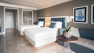 een hotelkamer met 2 bedden en een bank bij Caresse, a Luxury Collection Resort & Spa, Bodrum in Bitez