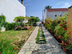 a garden with flowers and a stone pathway at ANNAS HOUSE in Psakoudia