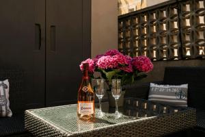 a bottle of wine and glasses on a table with flowers at Barcelona Beach Home in Barcelona