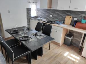 a kitchen with a table with wine glasses on it at Apartman Selce in Selce