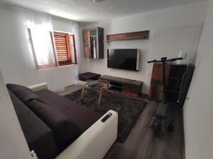 a living room with a couch and a flat screen tv at Apartman Selce in Selce