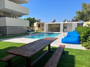 a backyard with a wooden table and a pool at Sia Mare in Kalívia Thorikoú
