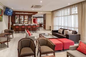 ein Wohnzimmer mit einem Sofa und einer Bar in der Unterkunft Hotel Savoy and Conference Centre in Mthatha