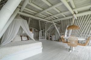 a bedroom with a bed and a table and chairs at Gravity Eco Boutique Hotel - Adults Only in Uluwatu