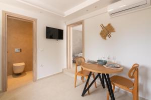 a room with a table and chairs and a television at Aqua Villa Faliraki in Faliraki