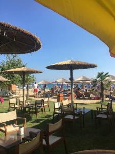a group of tables and chairs with umbrellas on a beach at Earthly paradise Kariani in Karianí