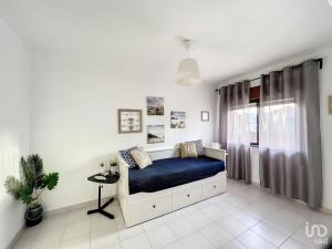 a bedroom with a blue bed and a window at T2 ideal para descansar e com Espanha ao lado in Vila Real de Santo António
