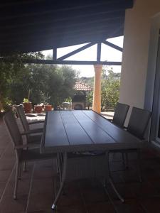 a table and chairs on a patio with a view of a grill at Earthly paradise Kariani in Karianí
