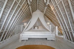a bed in a room with a pointed ceiling at Gravity Eco Boutique Hotel - Adults Only in Uluwatu