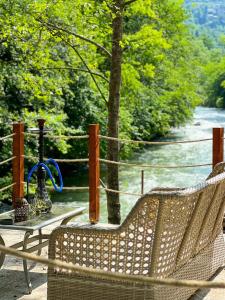 a table and a chair on a balcony with a view of a river at Heaven Forest Villa in Macka
