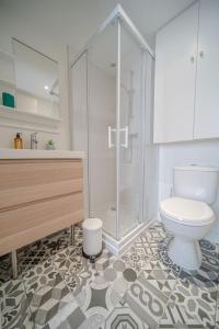 a bathroom with a toilet and a glass shower at La Maison Gratte Ciel-Appartement Paris-Jardin in Villeurbanne