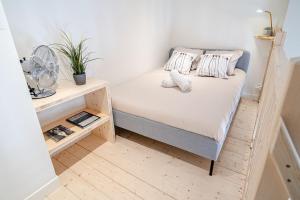 a small bedroom with a bed and a fan at La Maison Gratte Ciel-Appartement Paris-Jardin in Villeurbanne