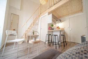 a small apartment with a staircase and chairs in a room at La Maison Gratte Ciel-Appartement Paris-Jardin in Villeurbanne