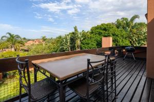 a wooden deck with a table and chairs on a balcony at San Lameer Villa 2409 - 3 Bedroom Standard - 6 pax - San Lameer Rental Agency in Southbroom