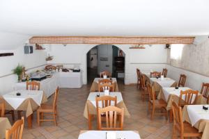 a restaurant with tables and chairs and a kitchen at Hotel Punta San Francesco in Vieste