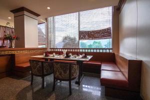 d'une salle à manger avec une table, des chaises et une fenêtre. dans l'établissement Arawan Riverside Hotel, à Pakse