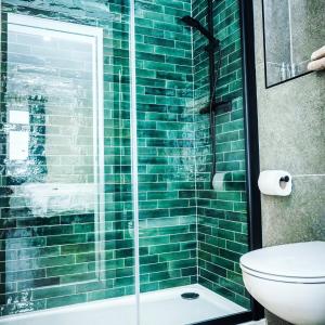 a green tiled bathroom with a shower and a toilet at Failte Hotel in Killarney