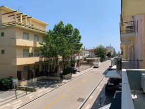 una strada vuota in una città con un edificio di Hotel Estense a Rimini