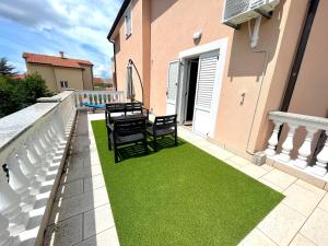 a patio with green grass on the side of a house at Villa Julie in Jadranovo