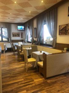 a dining room with tables and chairs and windows at Albergo Bernard in Canazei