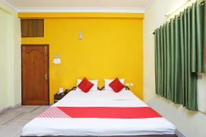 um quarto com uma cama grande e almofadas vermelhas em Honey Regency Near City Centre Salt Lake em Calcutá